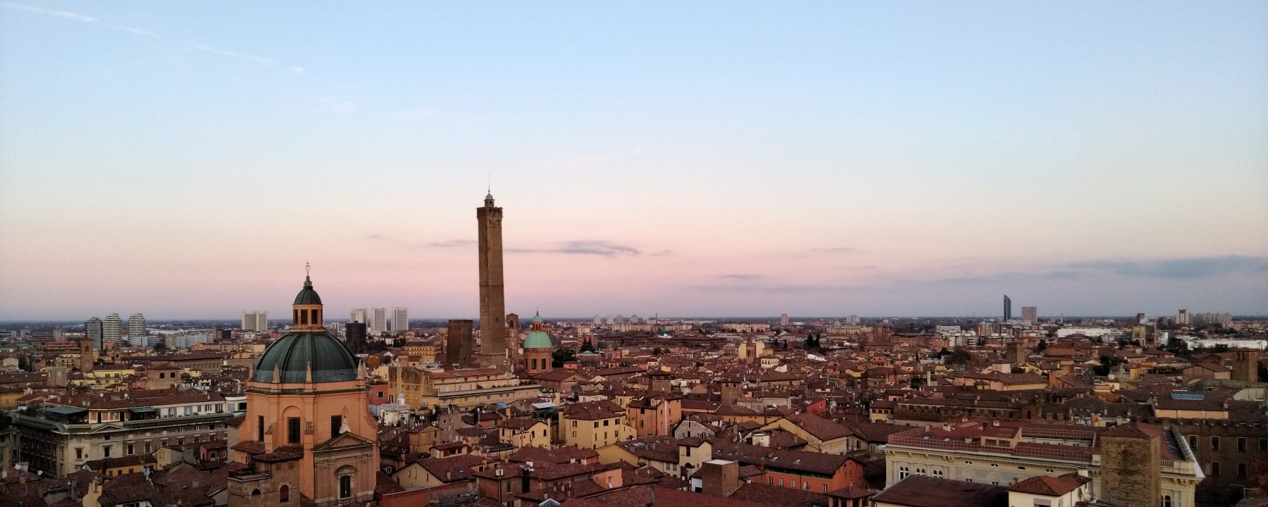 Vista dall'alto dei tetti di Bologna, emergono la Cupola della Chiesa di Santa Maria della Vita e le famose 2 Torri