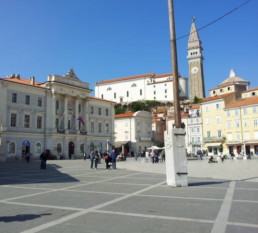 Piazza Tartini a Pirano con il palazzo comunale e gli eleganti edifici in stile veneziano; sullo sfondo svetta il campanile della chiesa di San Giorgio ispirato a quello di San Marco. Pirano, Slovenia