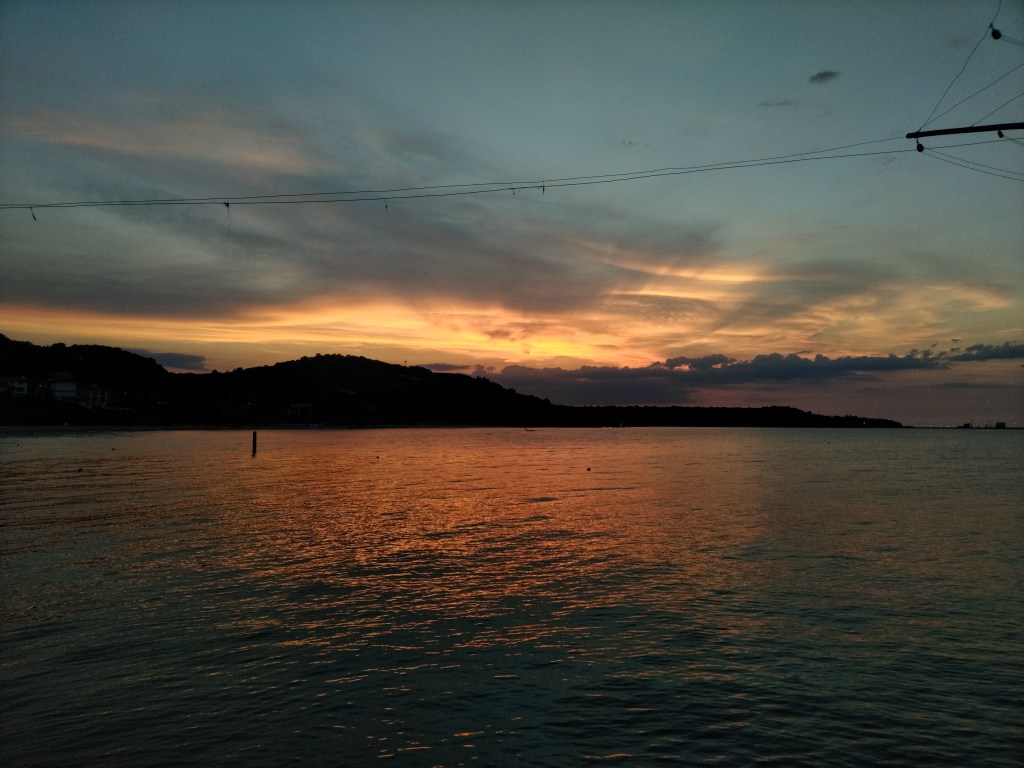 Tramonto sul mare visto da Marina di San Vito verso le colline con bellissimi colori arancioni, gialli e viola. Abruzzo, Italia