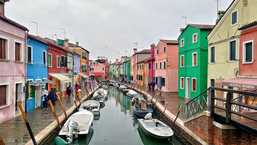 Un vero e proprio quadro pieno di colori vivaci e dettagli stupendi tra le barche, i canali, i ponti e le botteghe. Tre Ponti, Burano, Veneto