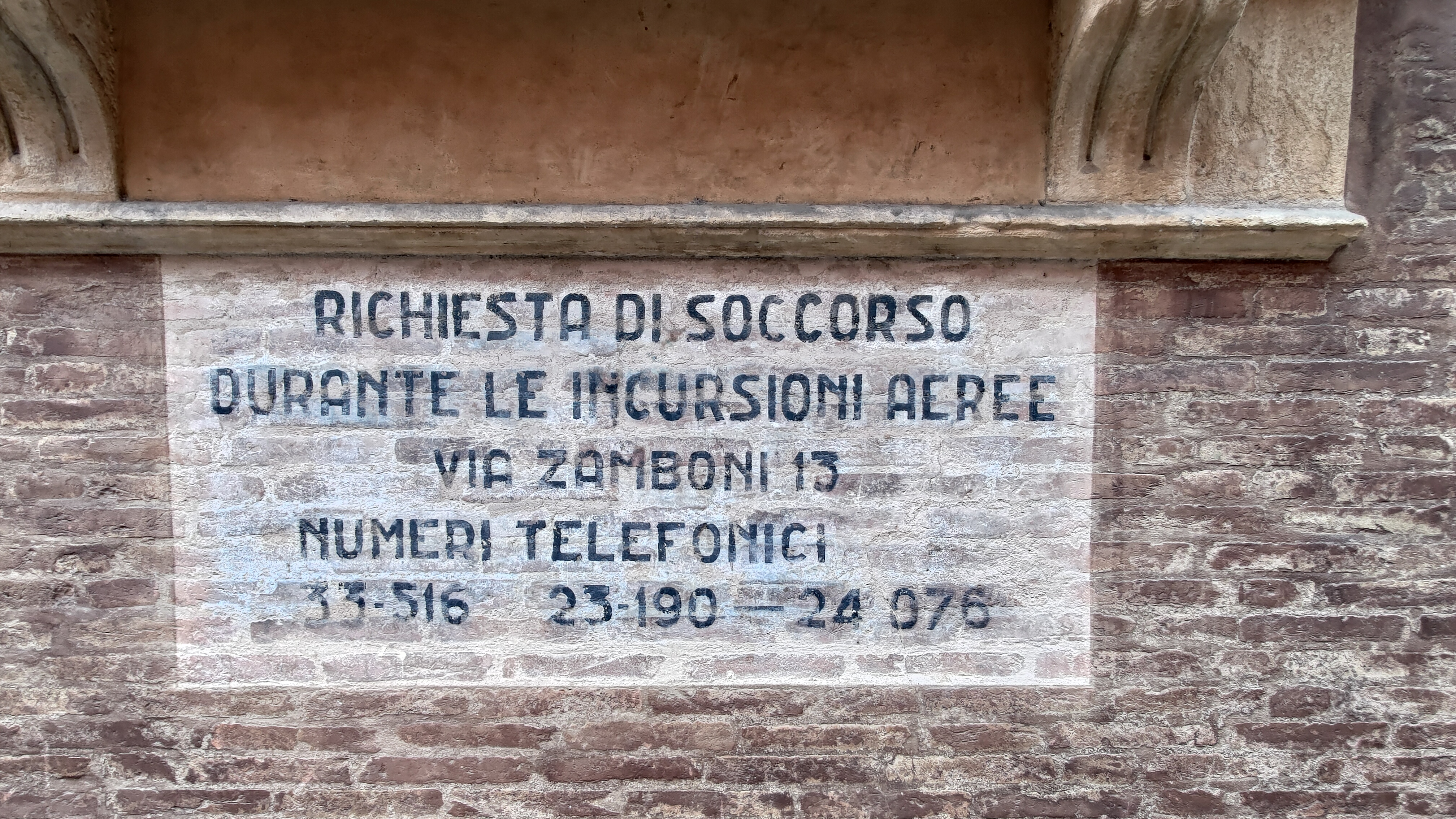Scritte che indicano il numero da chiamare durante i bombardamenti aerei della seconda guerra mondiale, questa scritta si trova su Palazzo Fantuzzi, a Bologna